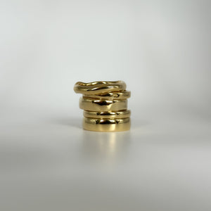 Stack of gold rings on a light gray background