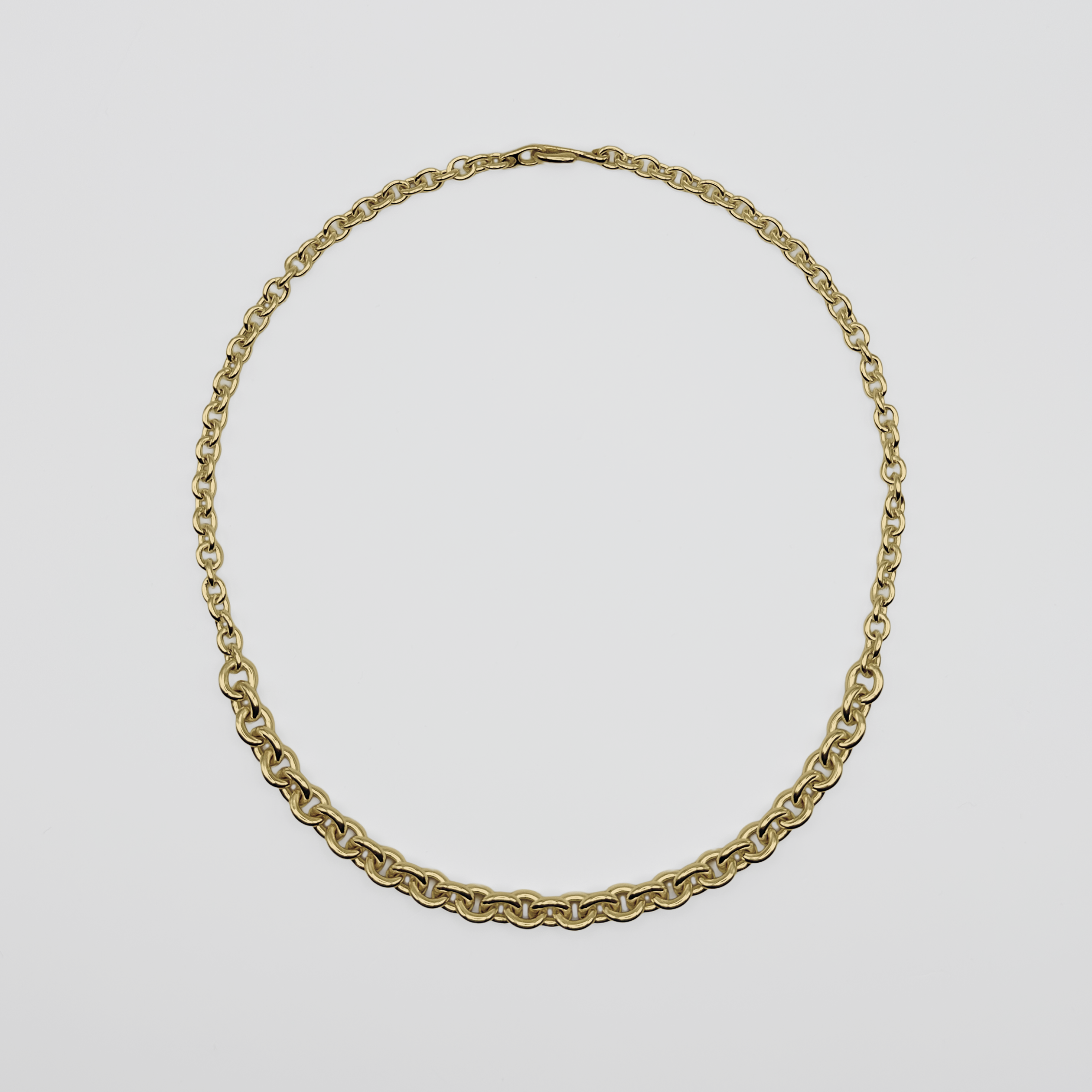Gold chain necklace on a light gray background