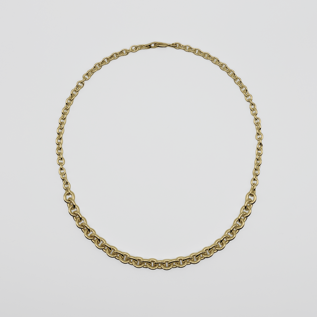 Gold chain necklace on a light gray background