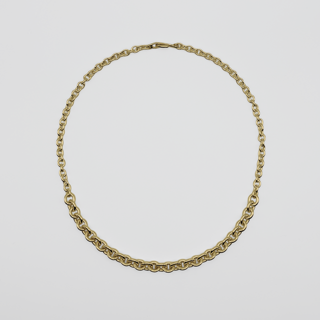Gold chain necklace on a light gray background
