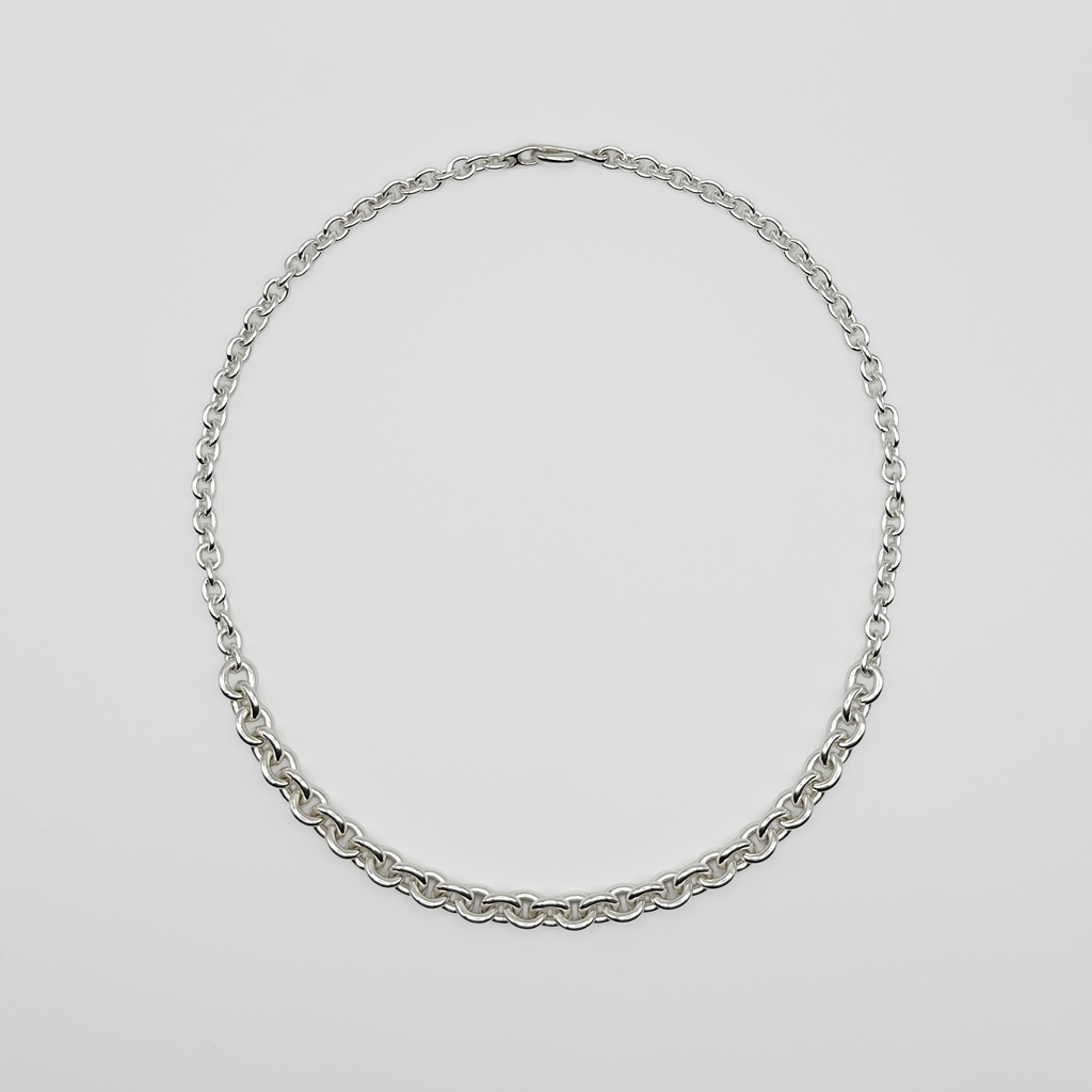 Silver chain necklace on a light gray background