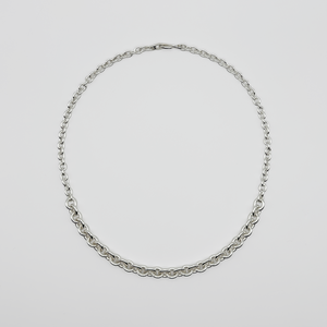 Silver chain necklace on a light gray background