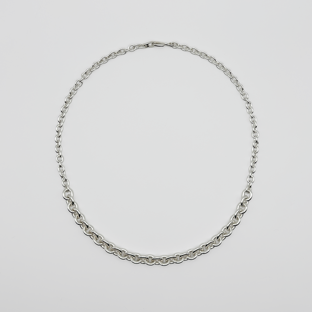Silver chain necklace on a light gray background