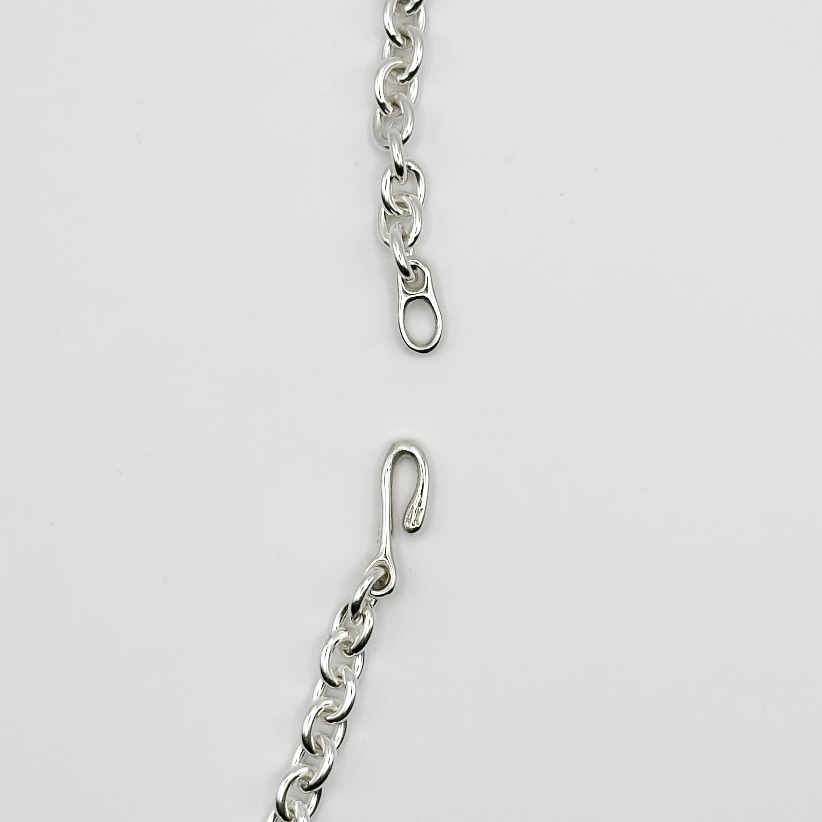 Silver chain with a clasp on a light gray background