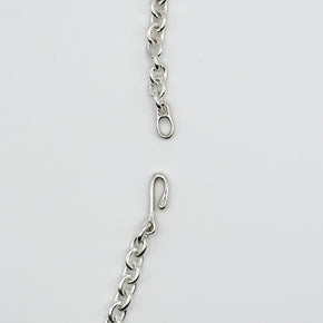 Silver chain with a clasp on a light gray background
