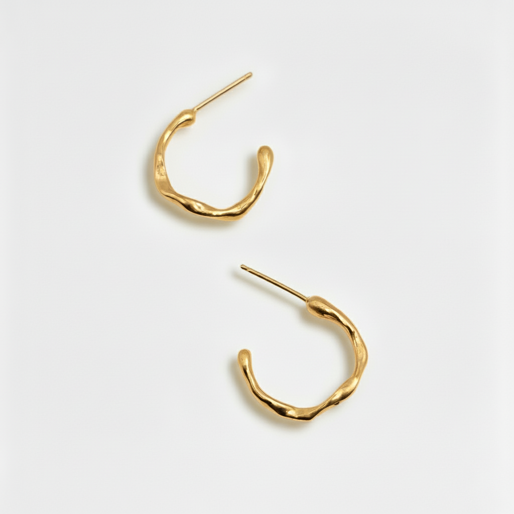 Gold organic hoop earrings on a white background