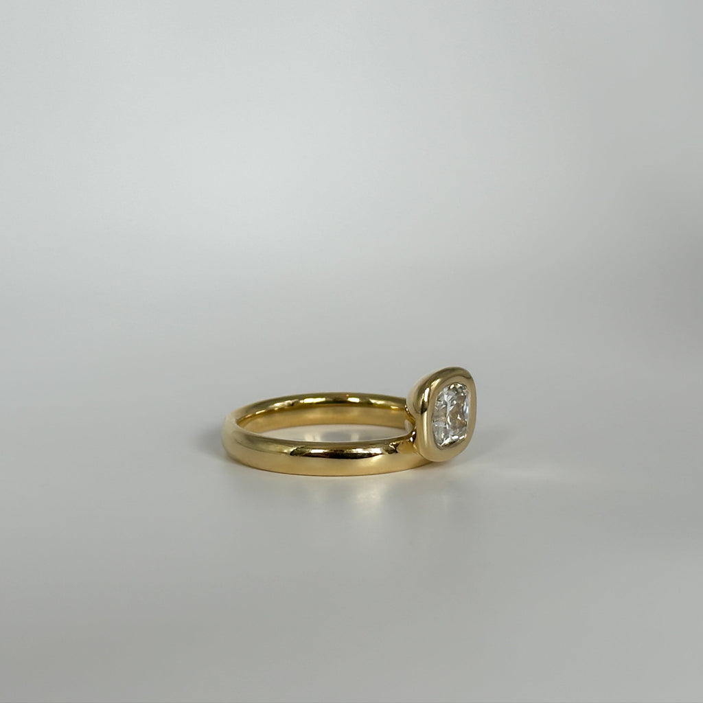 Gold ring with a diamond on a light gray background