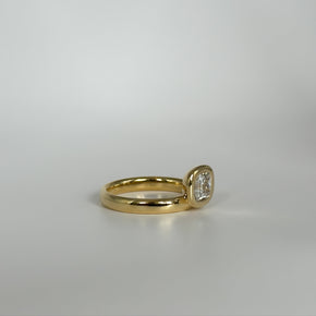 Gold ring with a diamond on a light gray background