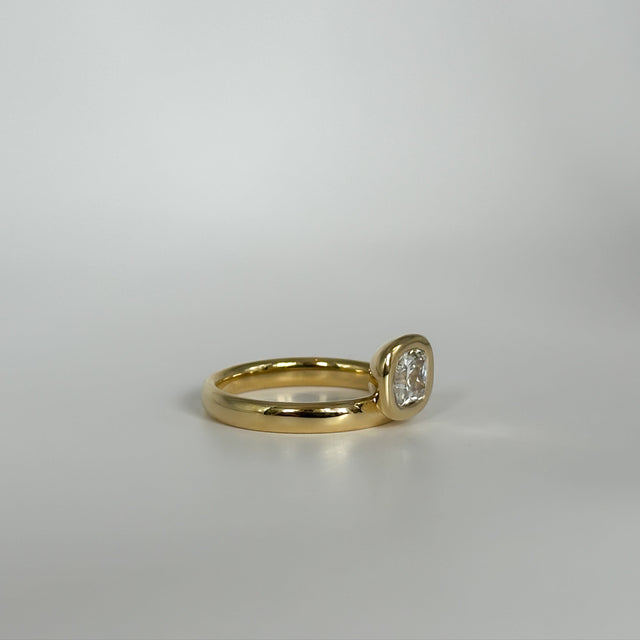 Gold ring with a diamond on a light gray background