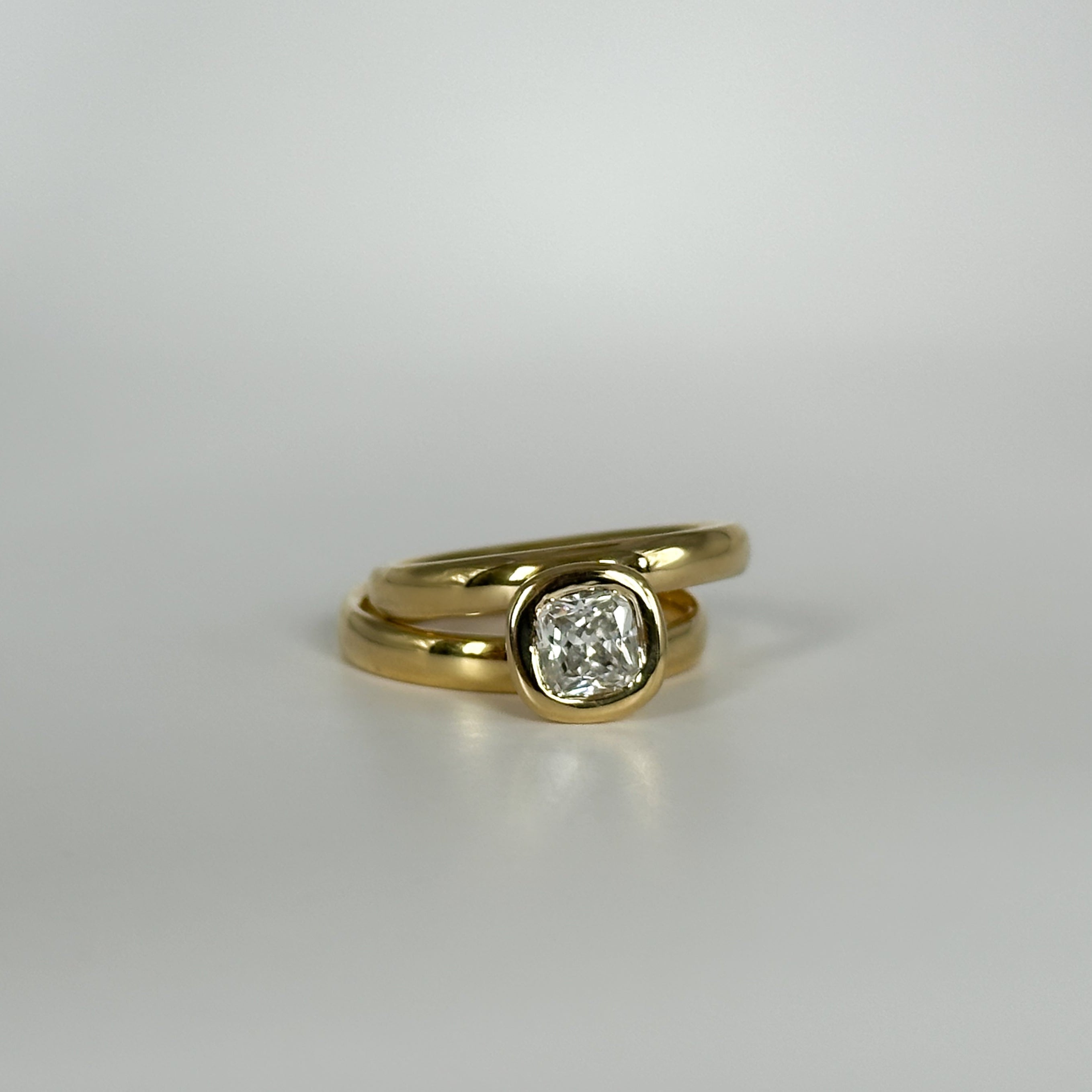 Gold ring with a diamond on a light gray background