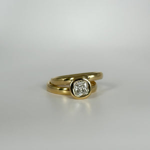 Gold ring with a diamond on a light gray background