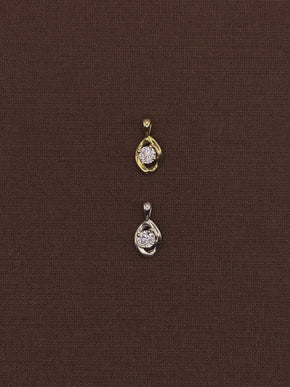 Two gold diamond pendants on a brown fabric background