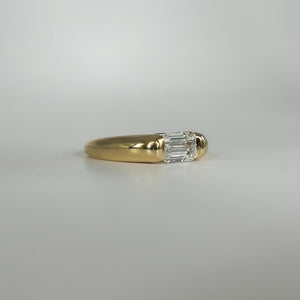 Gold ring with a diamond on a light gray background