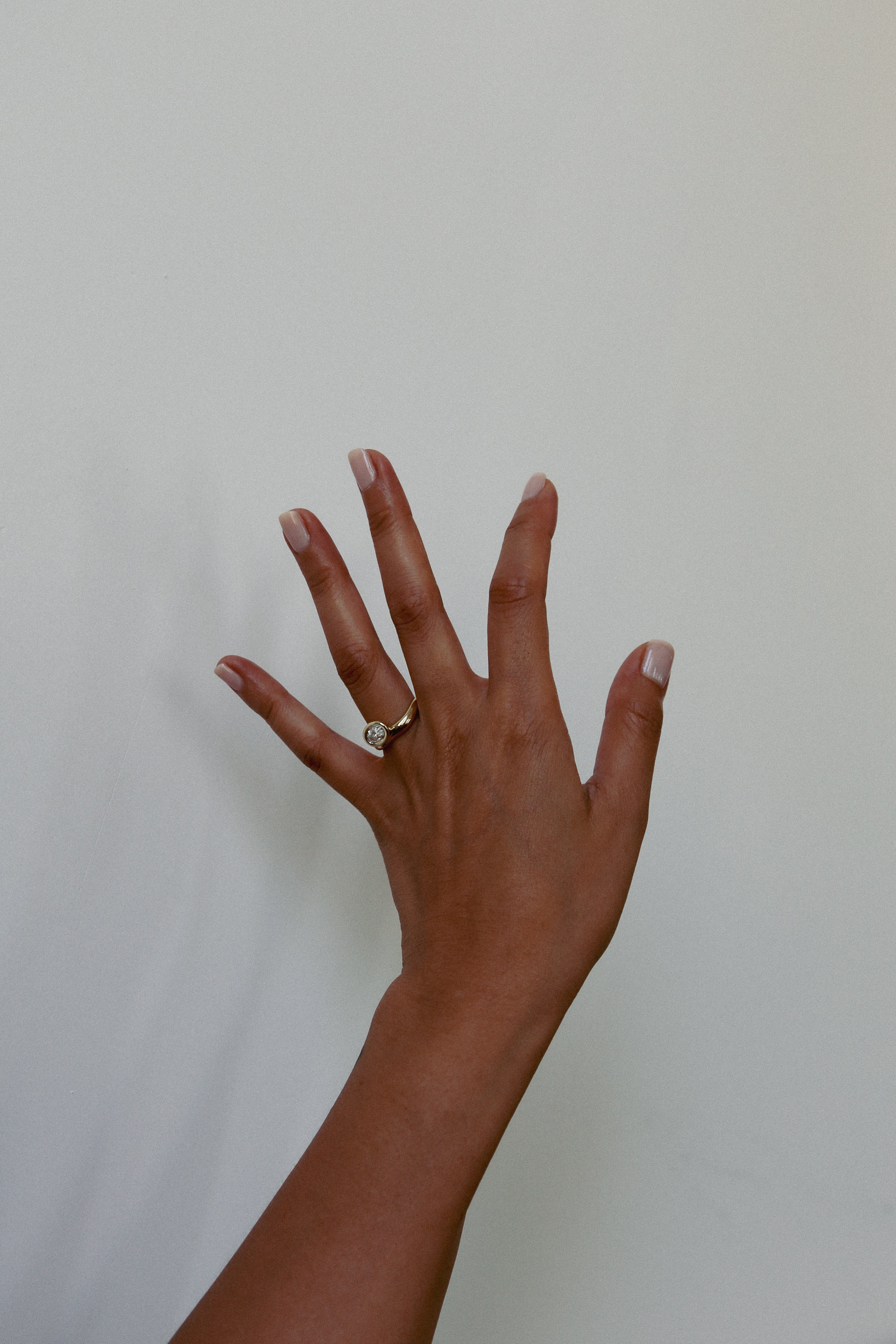 Hand with a ring on a plain background