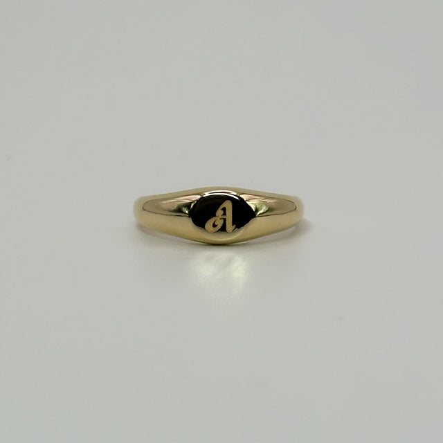 Gold ring with a small engraving on a light gray background