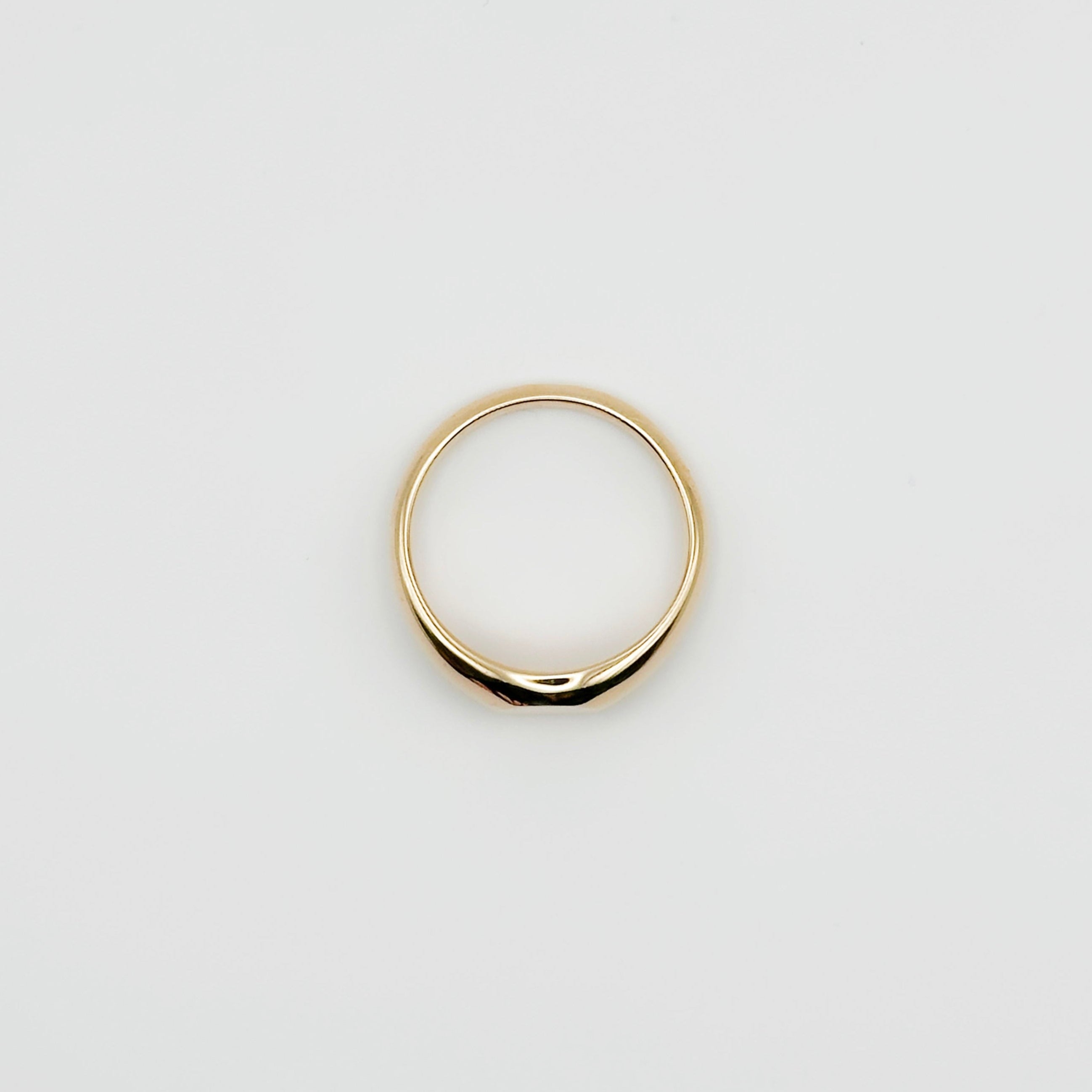 Gold ring on a light gray background