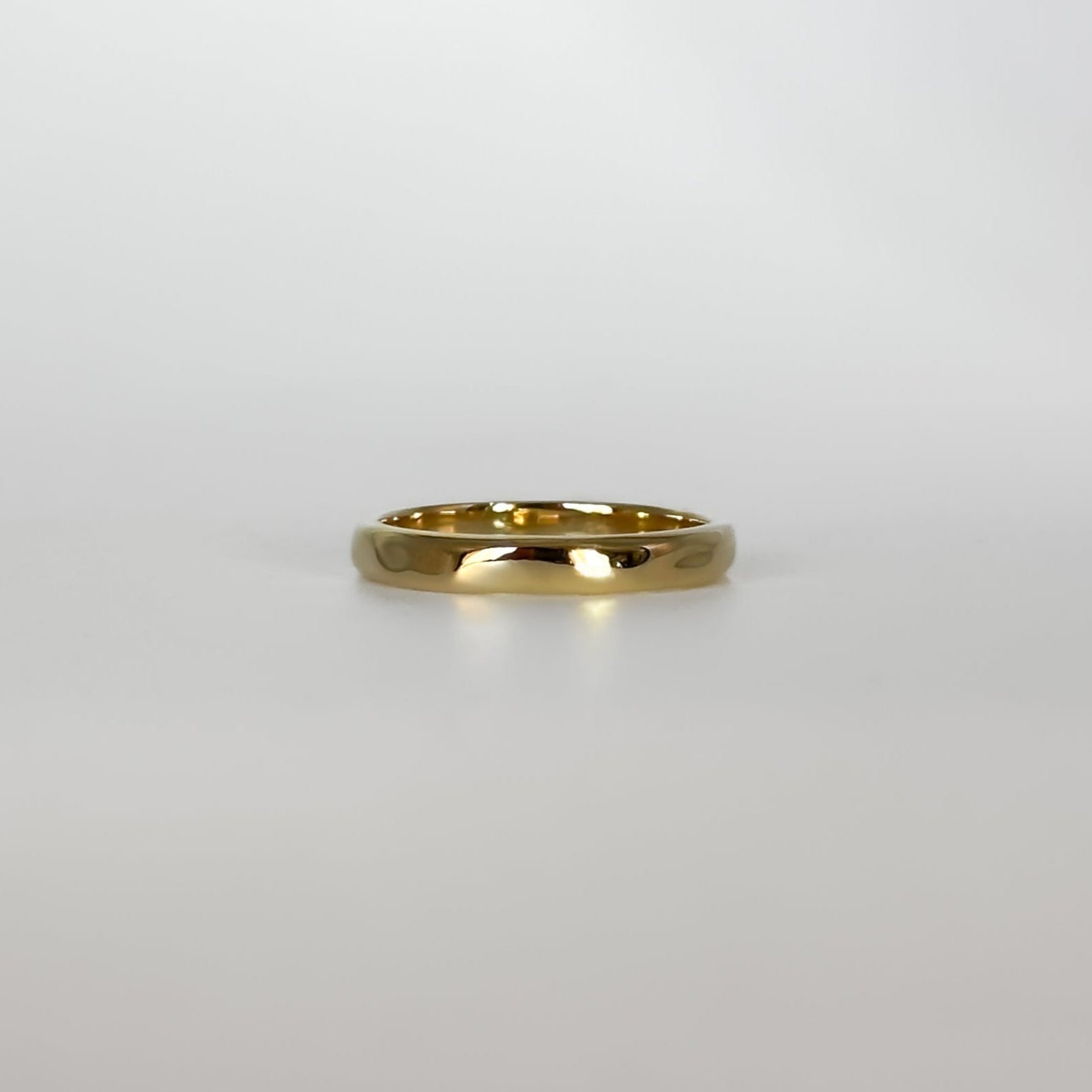 Gold ring on a light gray background