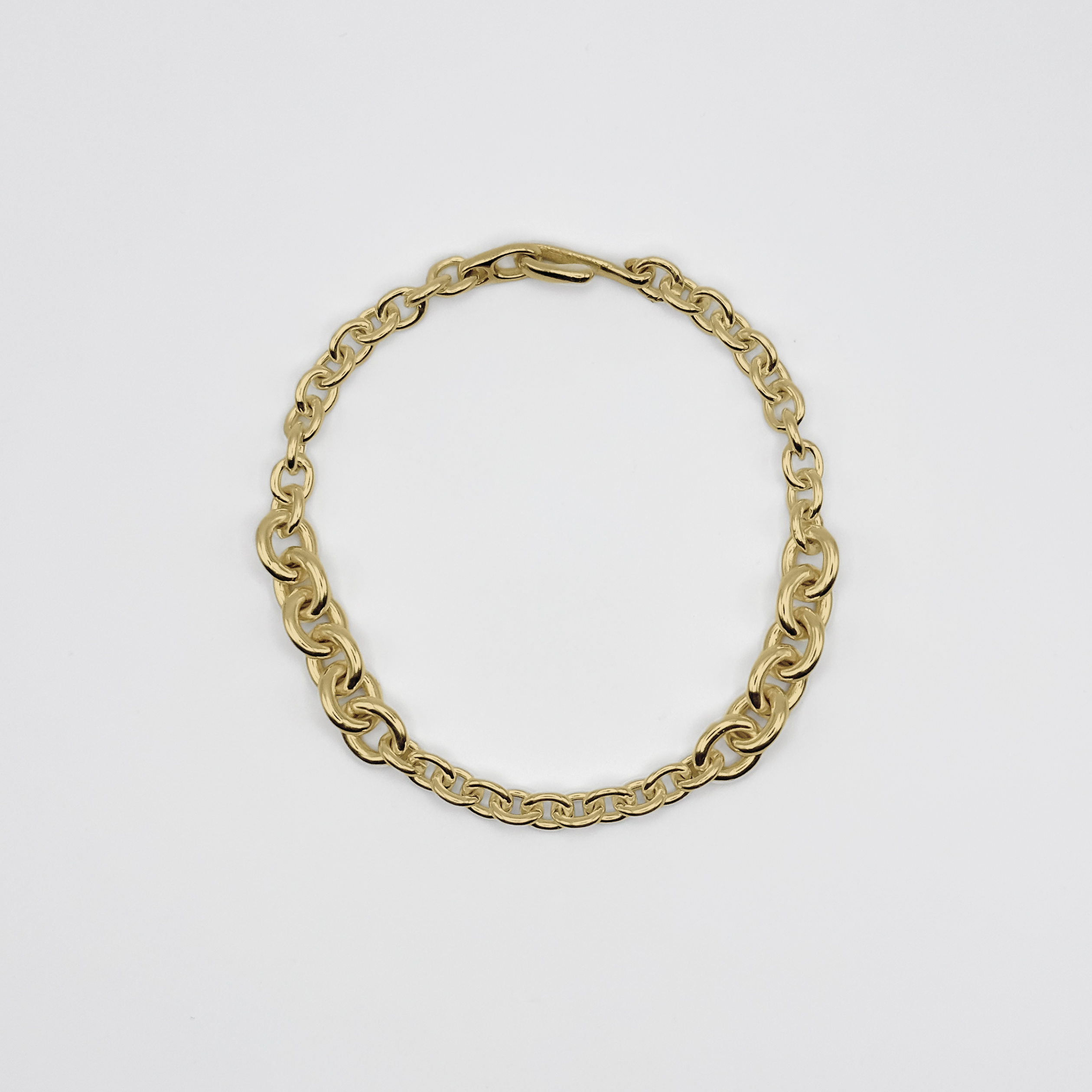 Gold chain bracelet on a light gray background