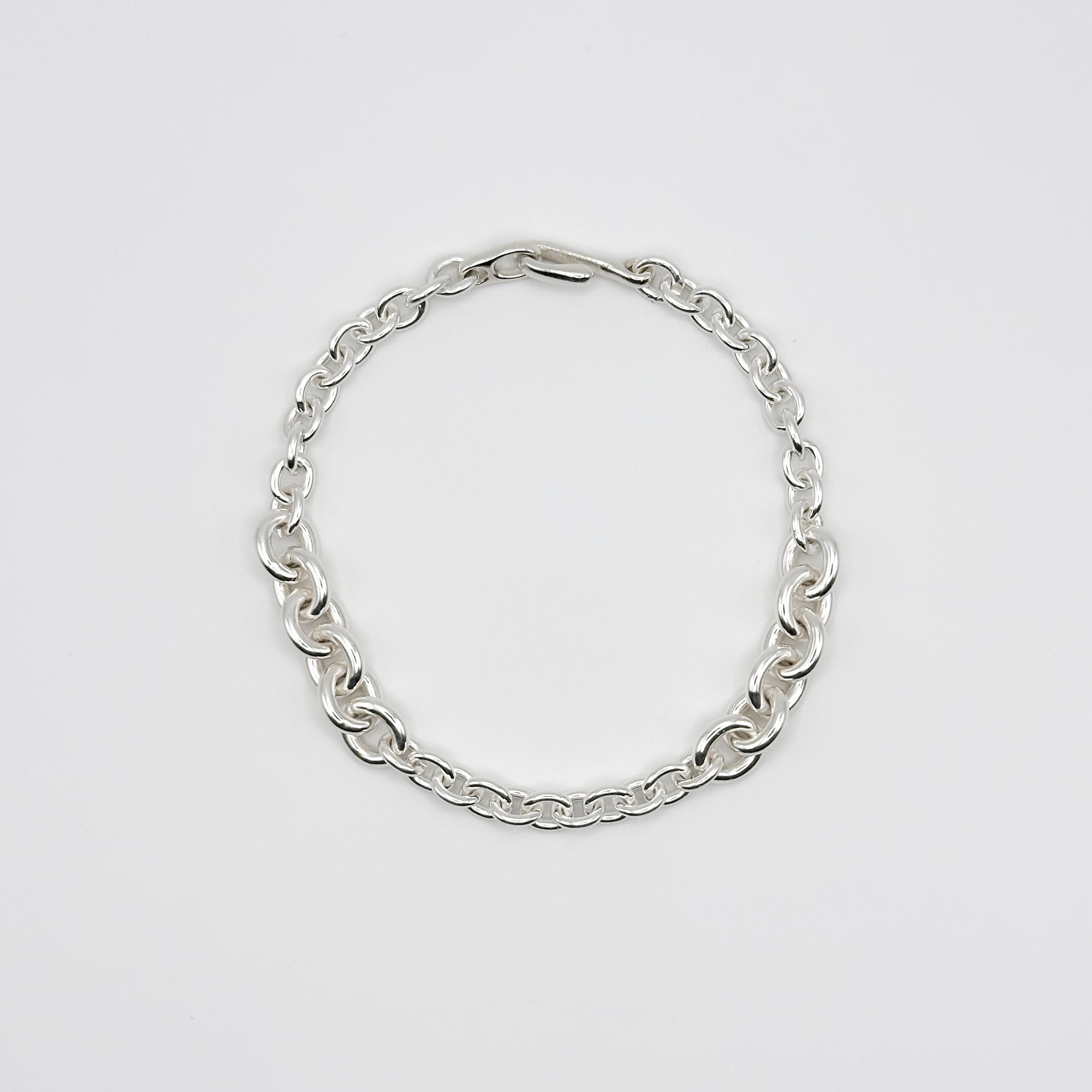 Silver chain bracelet on a light gray background