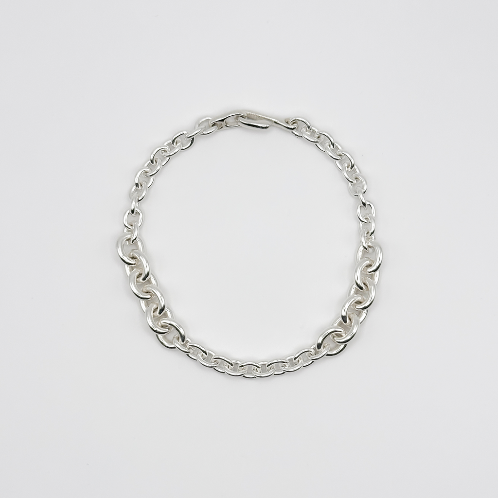 Silver chain bracelet on a light gray background