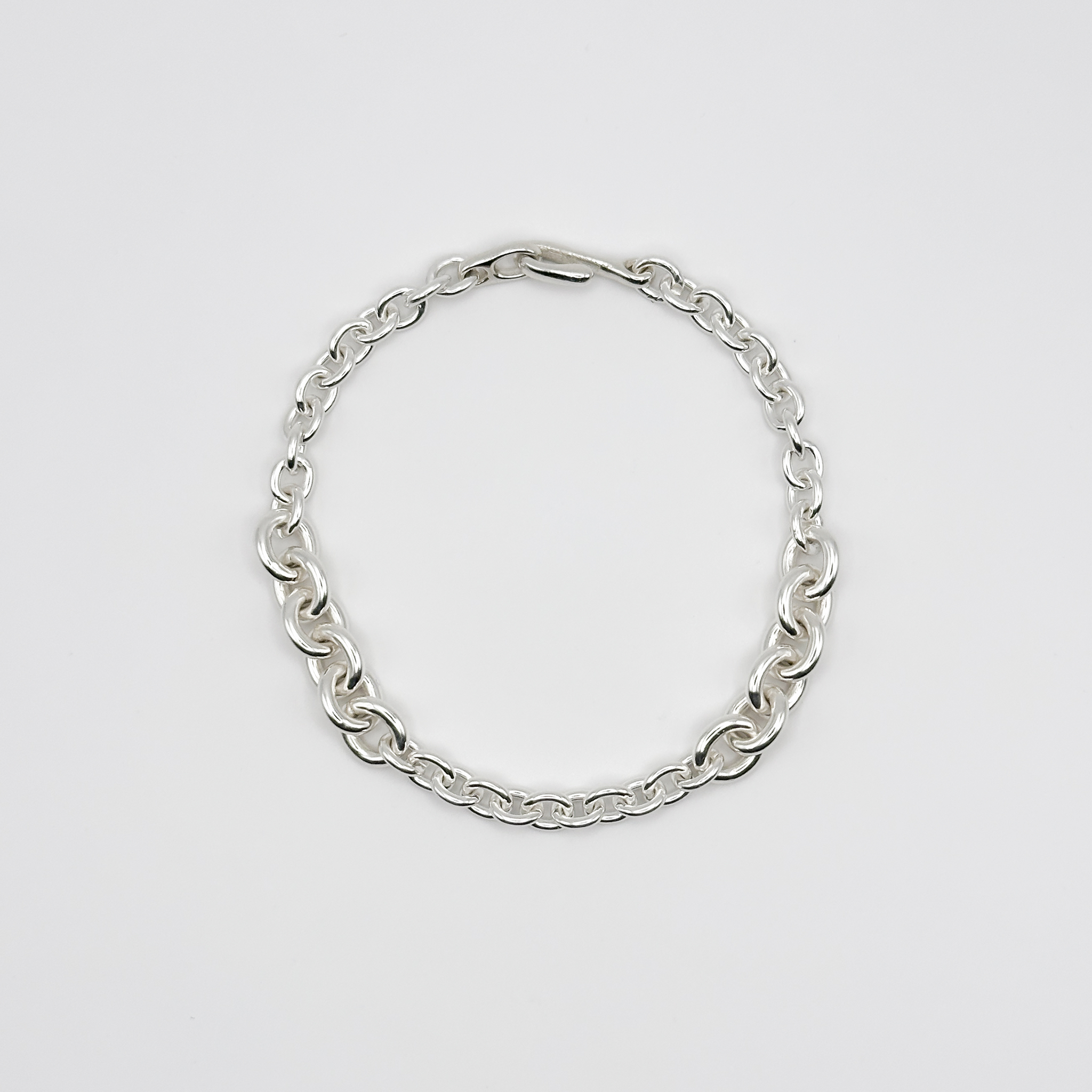 Silver chain bracelet on a light gray background