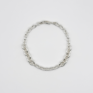 Silver chain bracelet on a light gray background