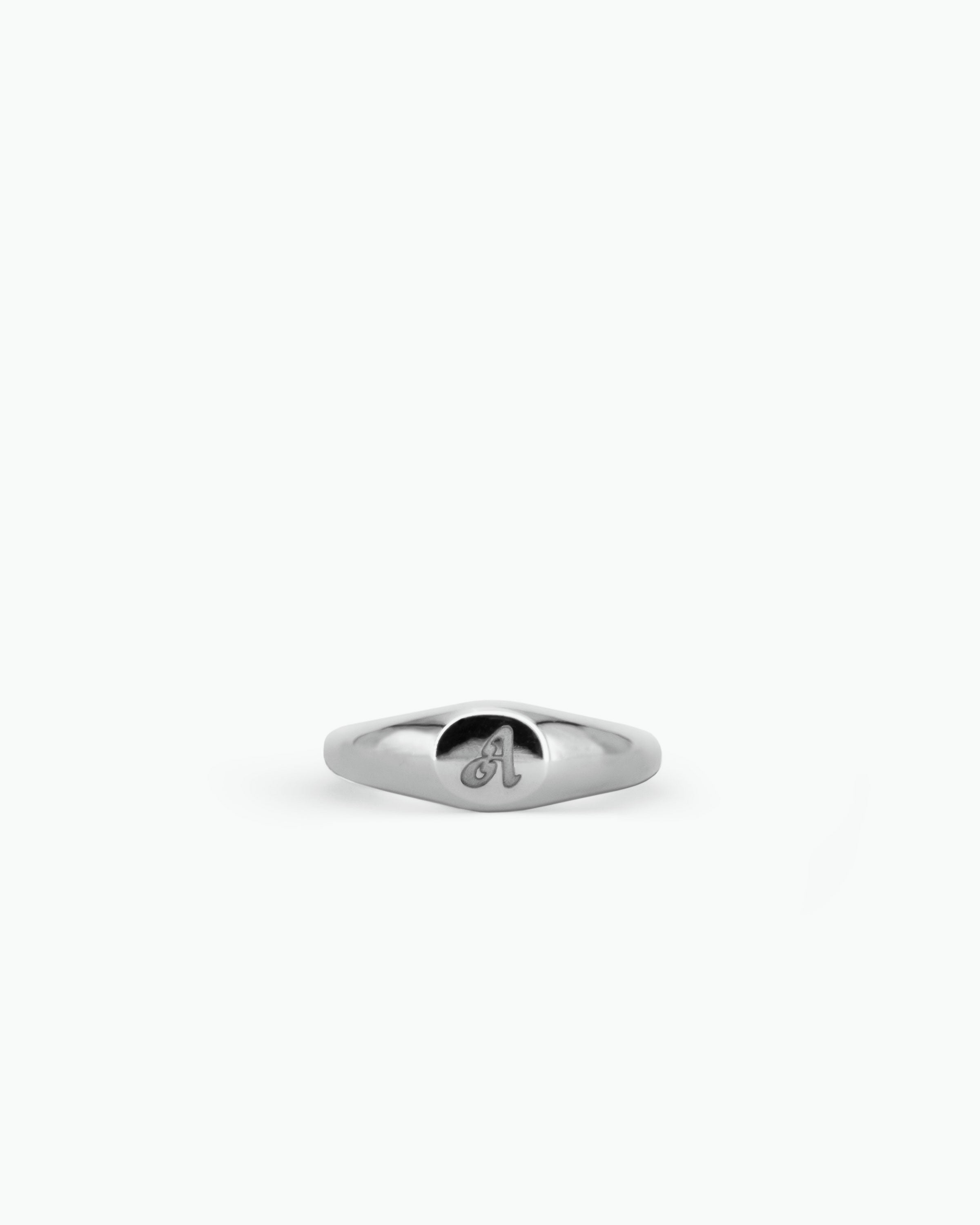 Silver signet ring with an engraving design on a white background