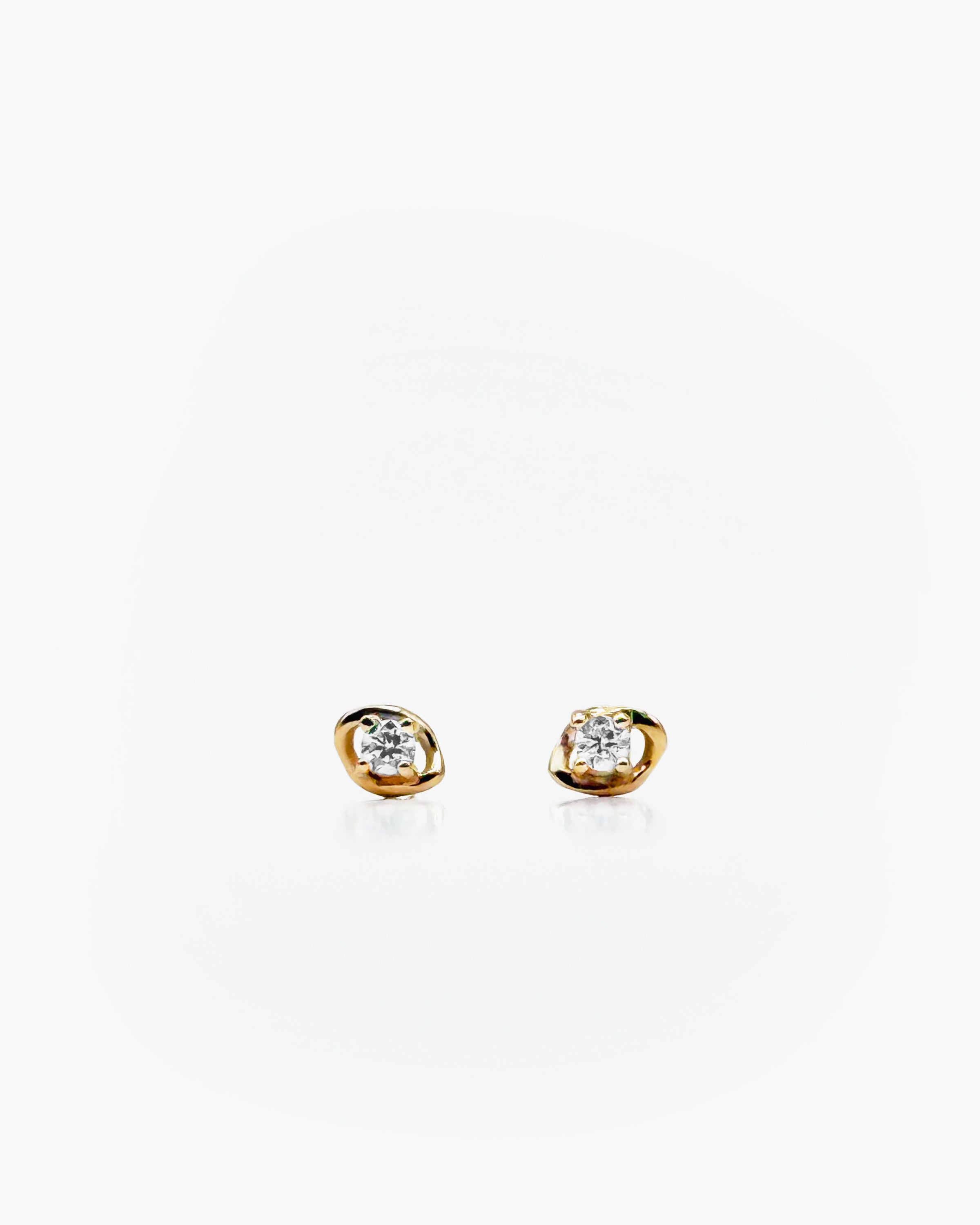 Pair of gold earrings with diamonds on a white background